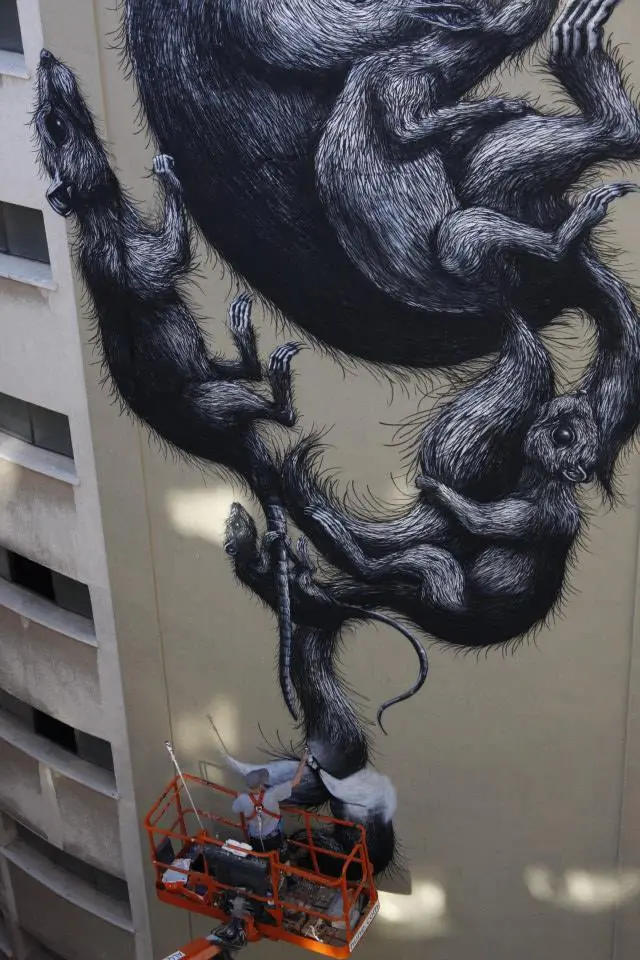 The lower portion of the mural with the lift and painters visible